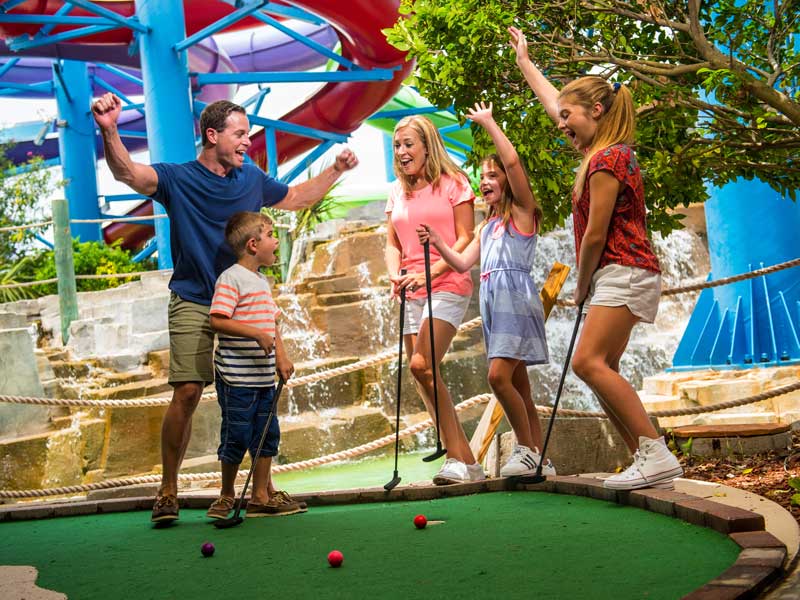 Family playing mini golf.